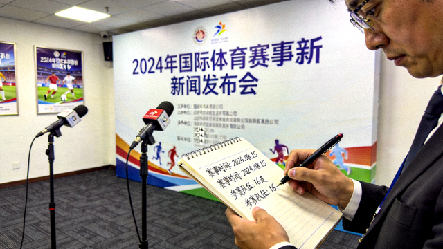 体育新闻发布现场记者记录赛事信息的画面